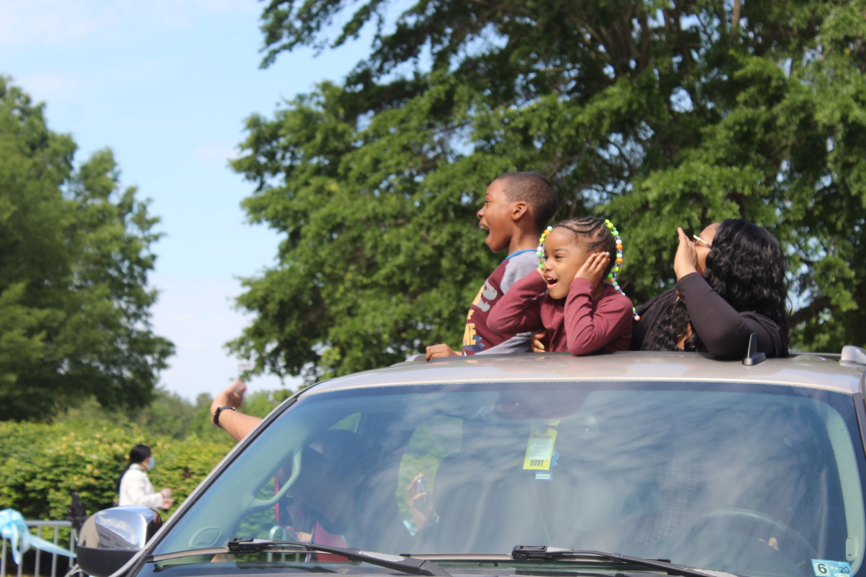 Little girl holds ears as family cheers.JPG